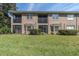 Rear exterior view of the home featuring screened patios and a well-maintained lawn at 4965 Anniston Cir, Tampa, FL 33647