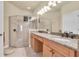 Bathroom with double sink vanity with granite countertops, decorative mirrors, and glass door shower at 4965 Anniston Cir, Tampa, FL 33647