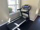 A modern SOLE treadmill in the gym area offers a convenient fitness option with natural light from the adjacent window at 4965 Anniston Cir, Tampa, FL 33647