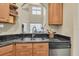 Kitchen sink with granite countertops and view to living area featuring lots of natural light at 4965 Anniston Cir, Tampa, FL 33647