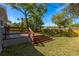 Large backyard featuring a wooden deck with stairs, lawn, and wooden fence at 5108 N Suwanee Ave, Tampa, FL 33603