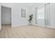 Bright bedroom featuring wood floors, white walls, and a plant near a window with sheer curtains at 5108 N Suwanee Ave, Tampa, FL 33603