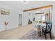 Open dining and living area with neutral color palette, wood beam accents, and light wood floors at 5108 N Suwanee Ave, Tampa, FL 33603