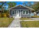 Charming gray home featuring new landscaping, a paved walkway, and a well-manicured lawn at 5108 N Suwanee Ave, Tampa, FL 33603
