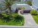 Aerial view of home with lush landscaping, brick driveway, and mature palm trees at 556 Johns Pass Ave, Madeira Beach, FL 33708