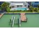 Aerial view of backyard with pool, spa, outdoor kitchen, and dock with boat lift at 556 Johns Pass Ave, Madeira Beach, FL 33708