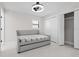 Bright bedroom features a bed with plaid cover, overhead fan, and closet storage at 556 Johns Pass Ave, Madeira Beach, FL 33708