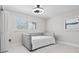 Bright bedroom features a bed with white cover, overhead fan, and closet storage at 556 Johns Pass Ave, Madeira Beach, FL 33708