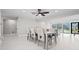 A bright dining room shows the indoor/outdoor living with pool views and a modern ceiling fan at 556 Johns Pass Ave, Madeira Beach, FL 33708