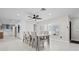 A dining room with views of the kitchen is ready for entertaining with tile floors and modern finishes at 556 Johns Pass Ave, Madeira Beach, FL 33708
