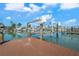 Waterfront property with a private boat lift, and serene canal views under a bright sky at 556 Johns Pass Ave, Madeira Beach, FL 33708