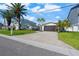Charming home with brick driveway, lush landscaping, and mature palm trees at 556 Johns Pass Ave, Madeira Beach, FL 33708