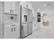 Kitchen with stainless steel refrigerator, white cabinets, and adjacent dining area with natural light at 556 Johns Pass Ave, Madeira Beach, FL 33708