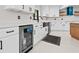 Modern kitchen features white cabinets, a black faucet, wine cooler, wooden island, and a stylish blue range hood at 556 Johns Pass Ave, Madeira Beach, FL 33708