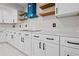 White cabinets with black hardware, a stylish blue range hood and floating shelves adorn this stunning kitchen at 556 Johns Pass Ave, Madeira Beach, FL 33708