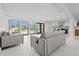 Bright, modern living room with light gray sofas and view of pool at 556 Johns Pass Ave, Madeira Beach, FL 33708