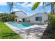 Beautiful pool with a spa and outdoor kitchen set against a backdrop of tropical landscaping at 556 Johns Pass Ave, Madeira Beach, FL 33708