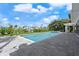 Sparkling pool and spa surrounded by a paved deck and lush landscaping on a bright day at 556 Johns Pass Ave, Madeira Beach, FL 33708