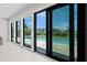 Stunning view of the pool area and lush landscaping through expansive glass windows at 556 Johns Pass Ave, Madeira Beach, FL 33708
