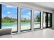 Expansive view of the pool and waterway through large windows in living area at 556 Johns Pass Ave, Madeira Beach, FL 33708