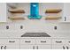 Close up of electric range with a stylish blue range hood with floating shelves at 556 Johns Pass Ave, Madeira Beach, FL 33708