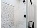 Close-up of glass enclosed shower with rain shower head and a tiled shower niche at 556 Johns Pass Ave, Madeira Beach, FL 33708