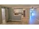 Open living space with tile flooring, sliding barn door to the left, and kitchen in the back at 5725 80Th N St # 107, St Petersburg, FL 33709