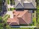 Aerial view of a home showcasing a terracotta roof and a screened-in porch, surrounded by green grass at 601 Viento De Avila, Tampa, FL 33613