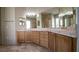 Bathroom featuring double vanity sinks, granite countertops, wood cabinets, and decorative tile flooring at 601 Viento De Avila, Tampa, FL 33613