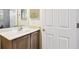 Bathroom with a white sink vanity, wood-look cabinets, stone countertop, and a white door at 601 Viento De Avila, Tampa, FL 33613