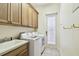 Laundry room featuring white washer and dryer, sink, and wooden cabinets at 601 Viento De Avila, Tampa, FL 33613