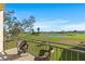 Balcony with seating overlooking lush golf course with pond and blue skies at 6140 Sun Blvd # 7, St Petersburg, FL 33715