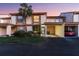 View of a townhouse with a covered carport, lush landscaping and a large palm tree in the front yard at 6140 Sun Blvd # 7, St Petersburg, FL 33715