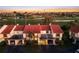A townhouse with a red roof and two carport spaces overlooks a golf course and a skyline in the distance at 6140 Sun Blvd # 7, St Petersburg, FL 33715