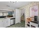 Bright kitchen showcasing stainless steel dishwasher, white cabinets, and stairs in view at 6140 Sun Blvd # 7, St Petersburg, FL 33715
