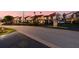 Exterior street view of townhomes at dusk with manicured landscaping and assigned parking at 6140 Sun Blvd # 7, St Petersburg, FL 33715