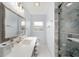 This bathroom features a marble tiled shower, a large mirror, and under sink storage at 6727 Burlington N Ave, St Petersburg, FL 33710
