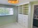 Bedroom showing built-in shelf and drawer unit with a window, and an ensuite bathroom with unique mirror at 6727 Burlington N Ave, St Petersburg, FL 33710