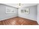 Bedroom features hardwood flooring, ceiling fan, and two bright windows at 6727 Burlington N Ave, St Petersburg, FL 33710