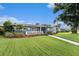 Charming single-story home featuring a well-maintained lawn, inviting front porch, and vibrant landscaping with a brick walkway at 6727 Burlington N Ave, St Petersburg, FL 33710