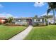 Charming single-story home featuring a well-maintained lawn, inviting front porch, and vibrant landscaping with a brick walkway at 6727 Burlington N Ave, St Petersburg, FL 33710