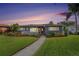 Charming single-story home featuring a well-maintained lawn, inviting front porch, and vibrant landscaping with a brick walkway at 6727 Burlington N Ave, St Petersburg, FL 33710