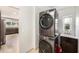 Modern laundry room features stacked washer and dryer and adjacent sink and cabinet at 6727 Burlington N Ave, St Petersburg, FL 33710