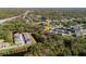 An aerial view shows the home in a wooded area near a highway with a pond and other homes nearby at 6732 Rocky Park St, Tampa, FL 33625