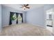 Spacious bedroom with a ceiling fan, carpet floors, and a view of the exterior at 6732 Rocky Park St, Tampa, FL 33625