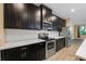 Kitchen showcasing dark cabinets, stainless steel appliances, and light countertops, open to a living space at 6732 Rocky Park St, Tampa, FL 33625