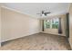 Bright, spacious living room with wood-style tile flooring, two windows, and a ceiling fan at 6732 Rocky Park St, Tampa, FL 33625