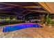 Screened-in pool area with lighting and landscaping at twilight at 706 Citrus Ct, Largo, FL 33770