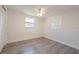 Bedroom featuring gray wood flooring, a ceiling fan, and a window at 7322 Mako Dr, Hudson, FL 34667