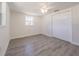 Bedroom featuring gray wood flooring, a ceiling fan, a window, and a closet at 7322 Mako Dr, Hudson, FL 34667